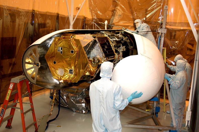 Workers in the Multi-Purpose Processing Facility move the second half of the fairing into place around the Solar Radiation and Climate Experiment (SORCE) satellite (left). When complete, the satellite will be installed in the Pegasus XL launch vehicle. Built by Orbital Sciences Corporation (OSC), SORCE will study and measure solar irradiance as a source of energy in the Earth's atmosphere. The launch of SORCE is scheduled for Jan. 25 at 3:14 p.m. from Cape Canaveral Air Force Station, Fla. The drop of the Pegasus will be from OSC's L-1011 aircraft at an altitude of 39,000 feet over the Atlantic Ocean approximately 100 miles east-southeast of Cape Canaveral. KSC-03PD-0162.jpg